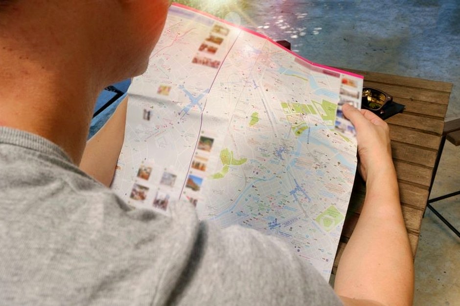A traveler reading a folded paper map.